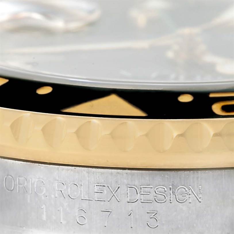 The image shows a close-up of the bezel and part of the case body of a Rolex GMT-Master 116713 Men's Stainless Steel Black Dial 116713 Men's Stainless Steel Black Dial with model number 116713.