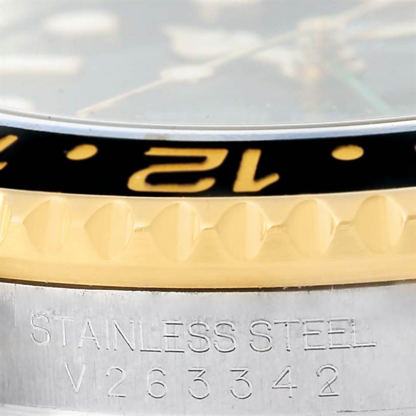 This close-up shows the bezel, serial number, and part of the case of a Rolex GMT-Master 116713 Men's Stainless Steel Black Dial 116713 Men's Stainless Steel Black Dial watch.