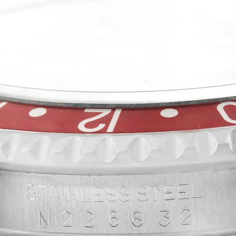 The close-up image shows the bezel and a portion of the casing of a Rolex GMT-Master 16700 Men
s Stainless Steel Black Dial 16700 Men
s Stainless Steel Black Dial watch, highlighting the "Stainless Steel" engraving and serial number.