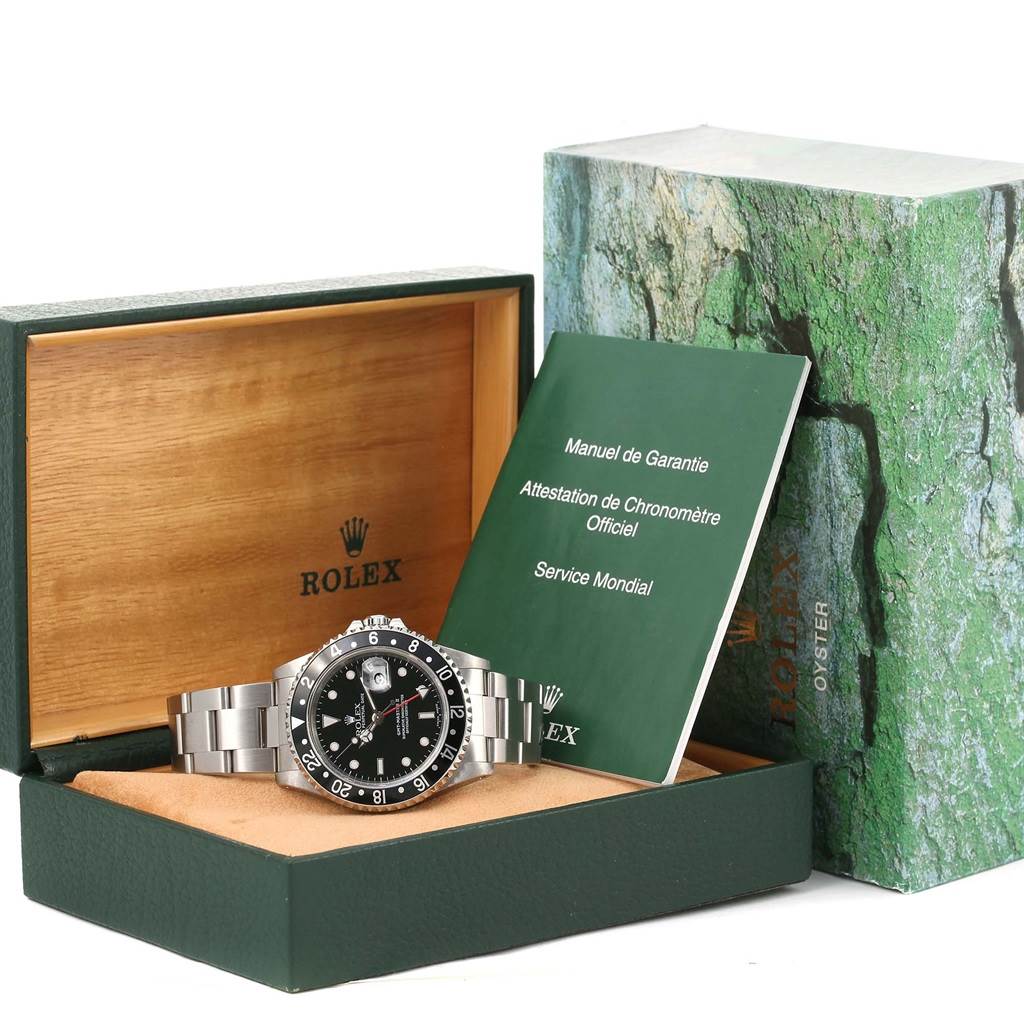 The image shows a Rolex GMT-Master 16710 Men's Stainless Steel Black Dial 16710 Men's Stainless Steel Black Dial watch with its bracelet, presented in an open box alongside official manuals.