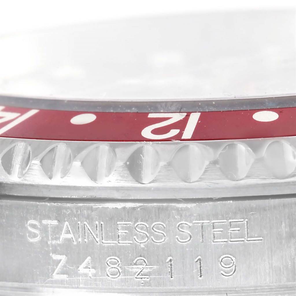 This close-up image shows the side of the Rolex GMT-Master 16710 Men's Stainless Steel Black Dial 16710 Men's Stainless Steel Black Dial model, including the bezel and the engraved serial/production number.