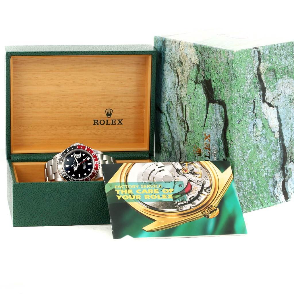 The image shows the Rolex GMT-Master 16710 Men's Stainless Steel Black Dial 16710 Men's Stainless Steel Black Dial watch at an angle, inside its open green box, with the booklet and boxed packaging beside it.