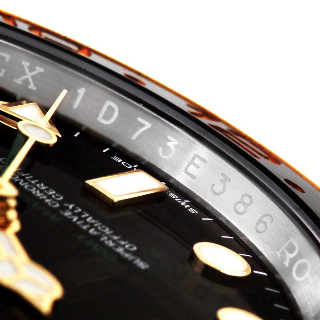 This close-up of the Rolex GMT-Master 116713 Men's Stainless Steel Black Dial 116713 Men's Stainless Steel Black Dial watch shows a portion of the dial, hands, markers, and part of the rehaut with engravings.