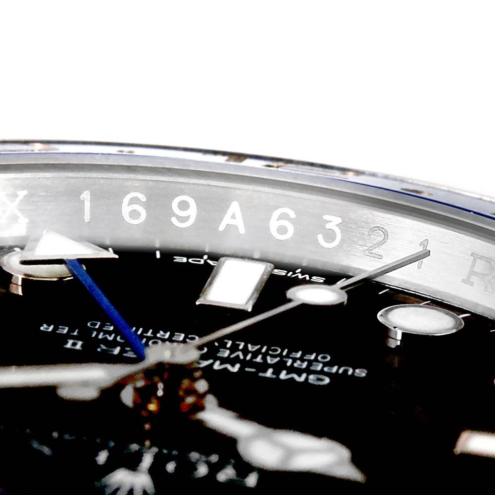 This close-up shows the dial, blue GMT hand, and partial serial number engraving on the bezel of a Rolex GMT-Master 116710BLNR Men's Stainless Steel Black Dial 116710BLNR Men's Stainless Steel Black Dial watch.