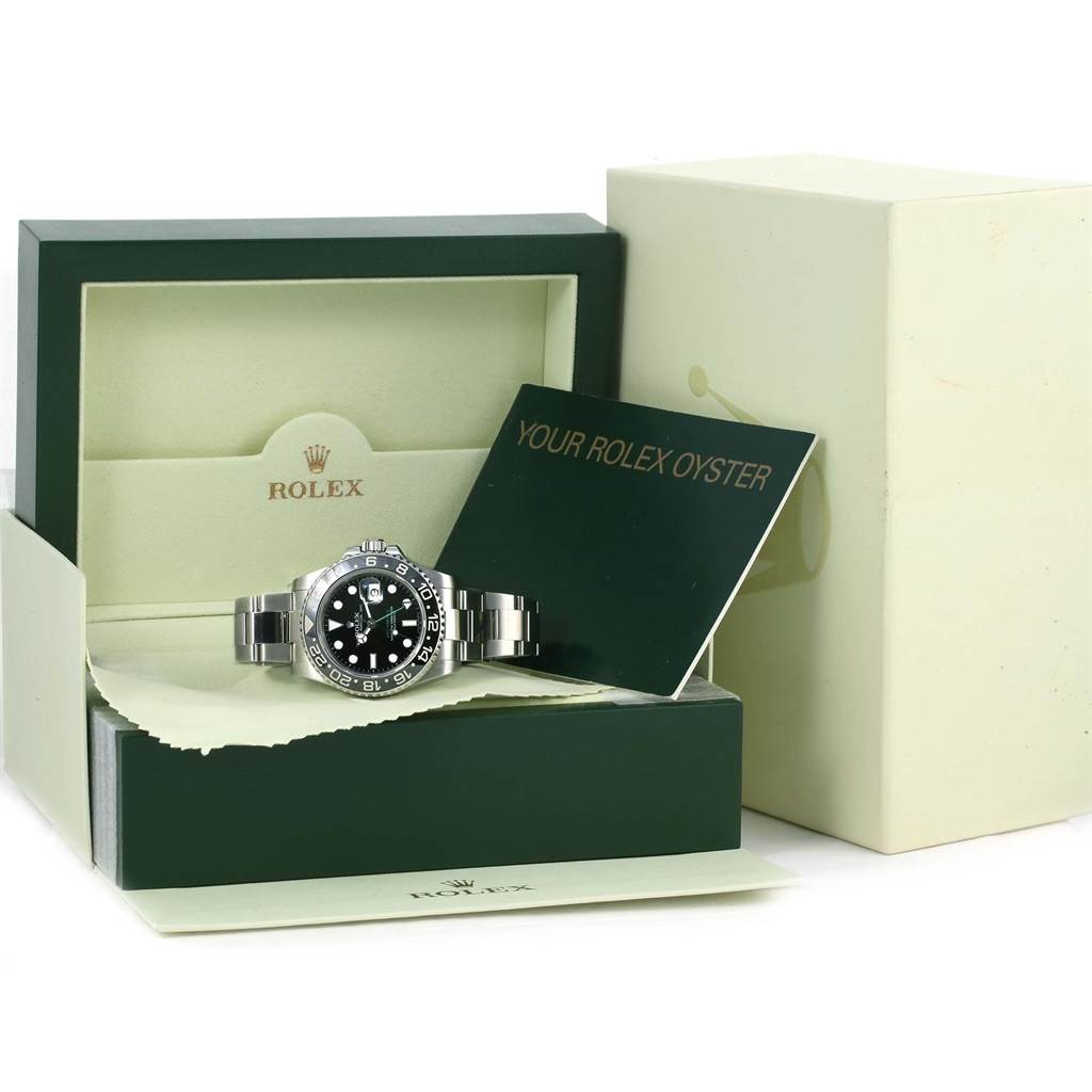 This image features a Rolex GMT-Master 116710 Men's Stainless Steel Black Dial 116710 Men's Stainless Steel Black Dial watch displayed in its open case, accompanied by a booklet and additional packaging.