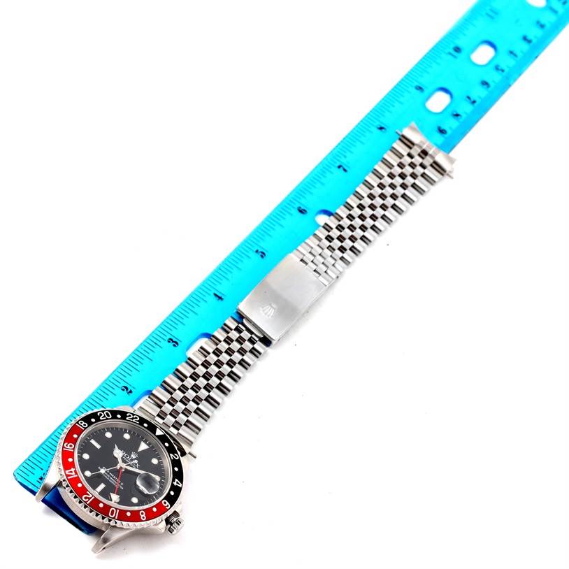 This image shows a Rolex GMT-Master 16710 Men's Stainless Steel Black Dial 16710 Men's Stainless Steel Black Dial watch from the top, featuring the bezel, dial, and the stainless steel bracelet alongside a ruler.