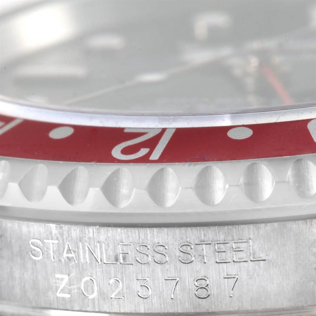 The image shows a close-up of the bezel and part of the case of a Rolex GMT-Master 16710 Men's Stainless Steel Black Dial 16710 Men's Stainless Steel Black Dial, displaying the stainless steel inscription and serial number.