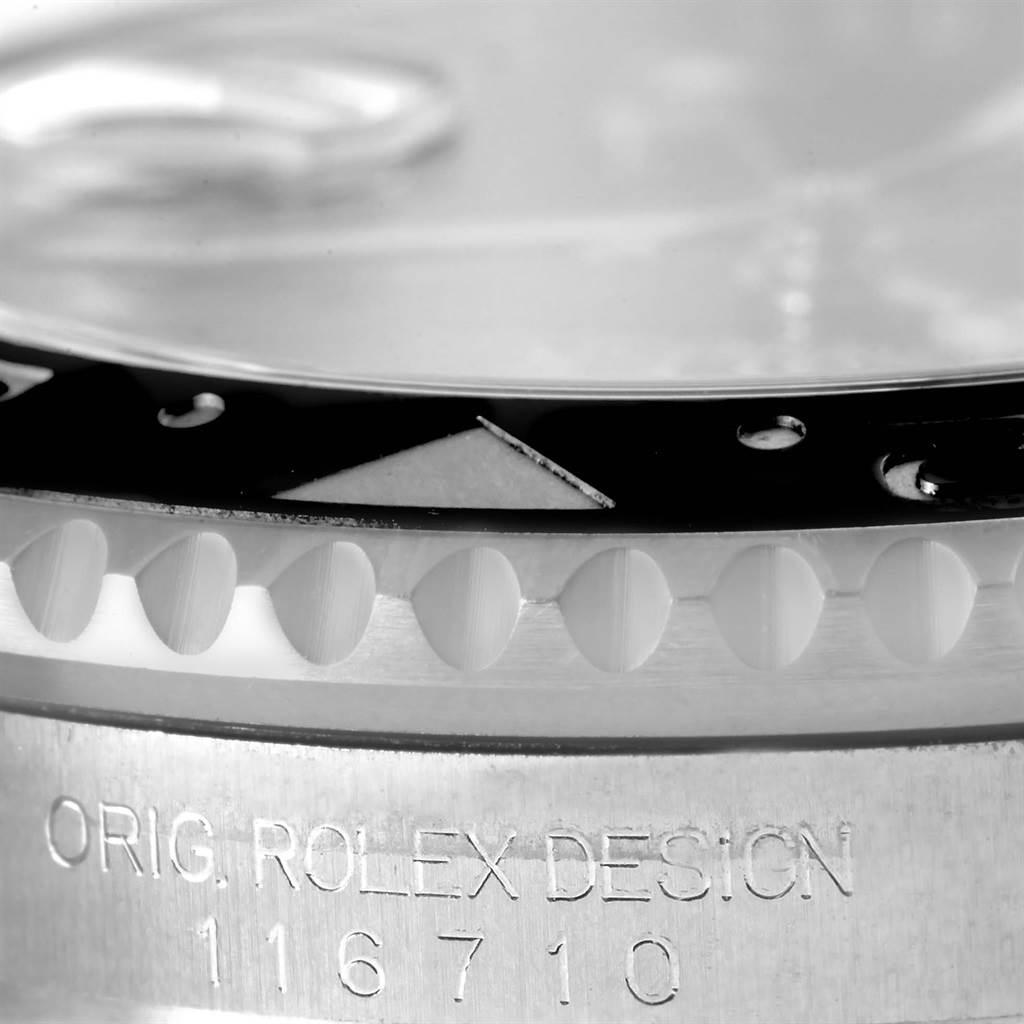 This close-up image of the Rolex GMT-Master 116710 Men
s Stainless Steel Black Dial 116710 Men
s Stainless Steel Black Dial shows a partial view of the bezel and engraved case side.