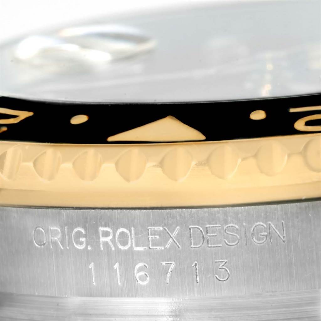 Close-up of a Rolex GMT-Master 116713 Men's Stainless Steel Black Dial 116713 Men's Stainless Steel Black Dial watch showing the bezel, part of the crystal, and side case with engraved model number.