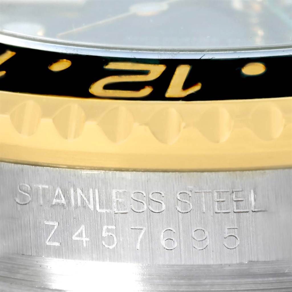 This close-up image shows the bezel, part of the dial, and the engraved case with serial number of a Rolex GMT-Master 116713 Men's Stainless Steel Black Dial 116713 Men's Stainless Steel Black Dial watch.