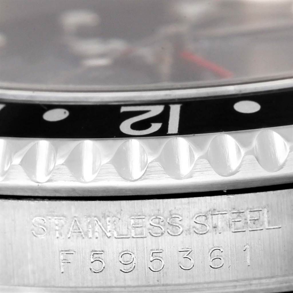 The close-up angle shows the bezel and part of the case of the Rolex GMT-Master 16710 Men's Stainless Steel Black Dial 16710 Men's Stainless Steel Black Dial watch, highlighting the "12" marker and the stainless steel engraving.