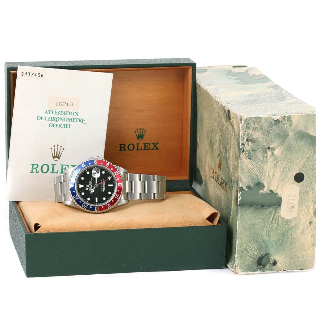 The image shows a Rolex GMT-Master 16710 Men's Stainless Steel Black Dial 16710 Men's Stainless Steel Black Dial watch with its original box, case, and papers at a slight upward angle.