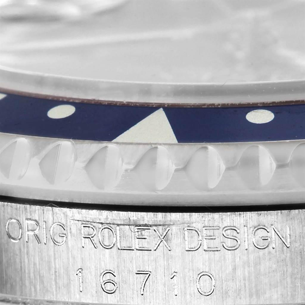 This is a close-up of the Rolex GMT-Master 16710 Men's Stainless Steel Black Dial 16710 Men's Stainless Steel Black Dial watch model 16710, showing part of the bezel, the crystal, and the engraved case.