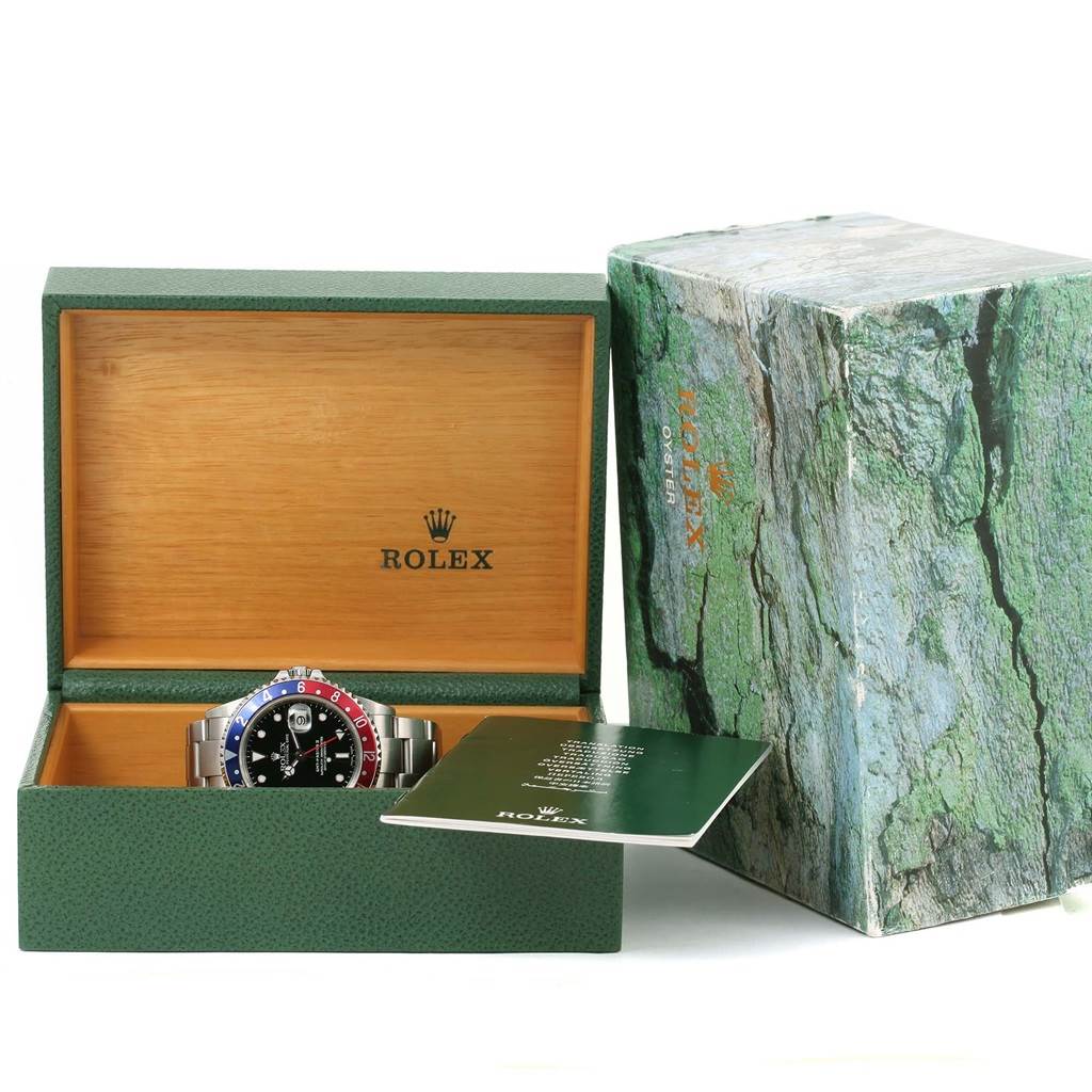 The image shows a Rolex GMT-Master 16710 Men's Stainless Steel Black Dial 16710 Men's Stainless Steel Black Dial watch placed inside its open green wooden box, along with an instruction booklet.
