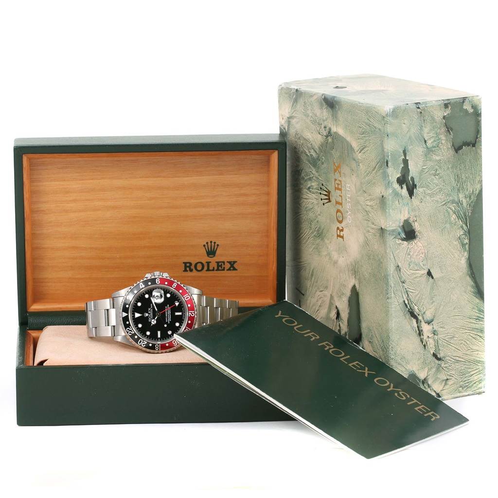 The Rolex GMT-Master 16710 Men
s Stainless Steel Black Dial 16710 Men
s Stainless Steel Black Dial watch is shown front-facing in an open box, accompanied by an exterior box and a booklet.