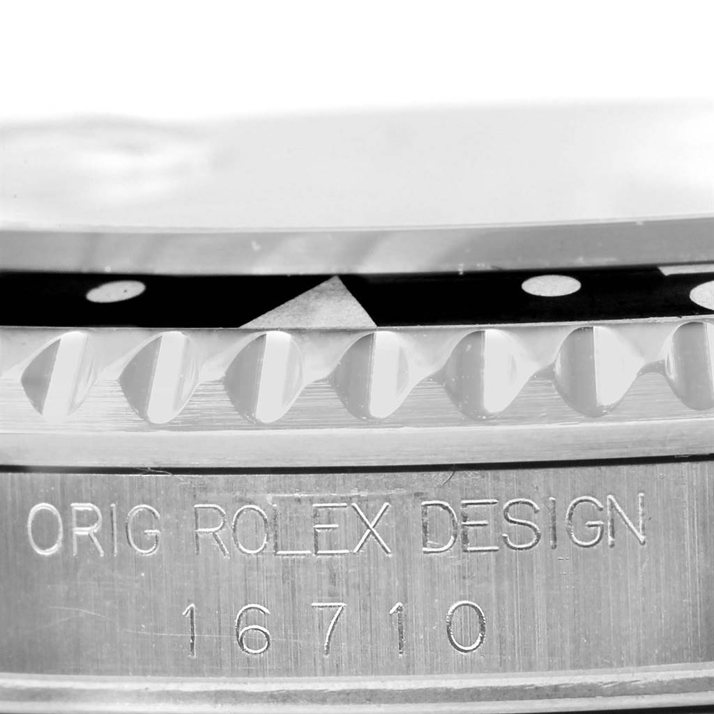 The image shows a close-up of the bezel, edge, and engraved design and model number "16710" of a Rolex GMT-Master 16710 Men
s Stainless Steel Black Dial 16710 Men
s Stainless Steel Black Dial watch.