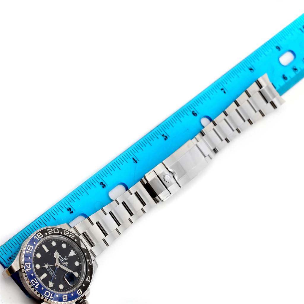 The image shows the face, bezel, and stainless steel bracelet of the Rolex GMT-Master 116710 Men's Stainless Steel Black Dial 116710 Men's Stainless Steel Black Dial watch, placed beside a blue ruler.
