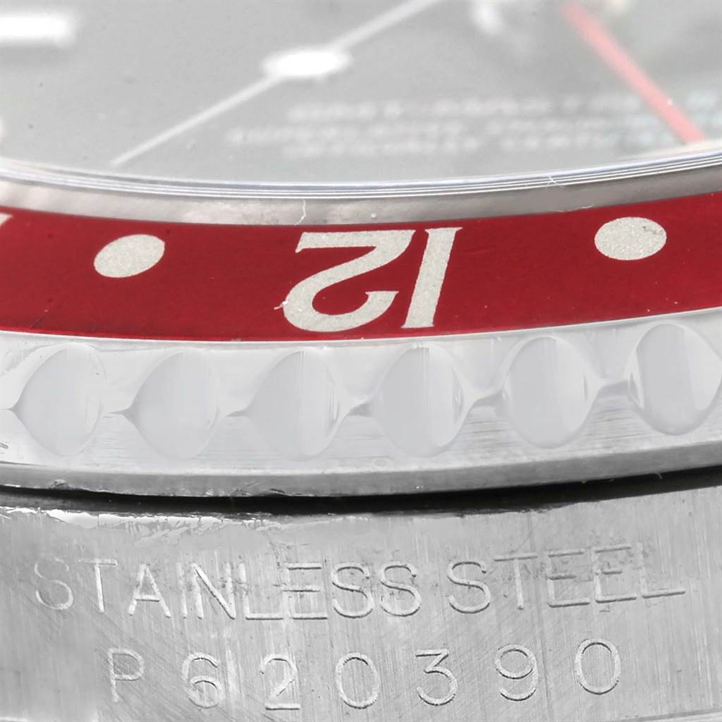 The image shows a close-up of the bezel and the case of a Rolex GMT-Master 16710 Men's Stainless Steel Black Dial 16710 Men's Stainless Steel Black Dial watch, focusing on the "12" hour marker and the "STAINLESS STEEL" engraving.