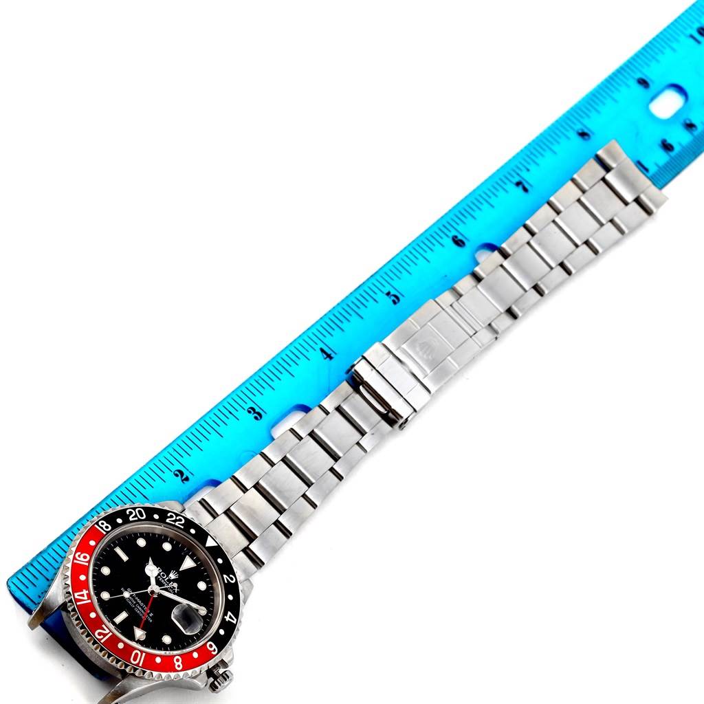 This image shows a Rolex GMT-Master 16710 Men's Stainless Steel Black Dial 16710 Men's Stainless Steel Black Dial watch with a partial view of its face and bracelet next to a blue ruler for scale.