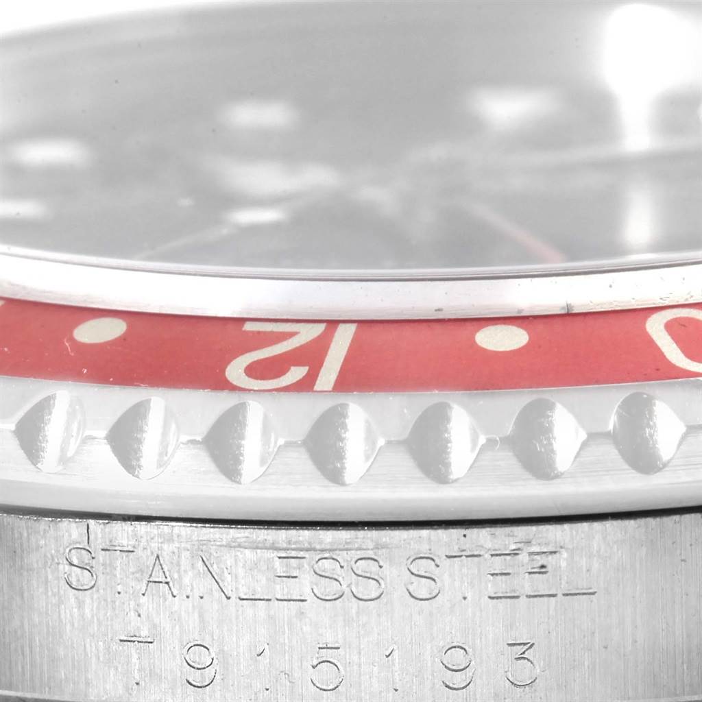 This close-up image of the Rolex GMT-Master 16700 Men's Stainless Steel Black Dial 16700 Men's Stainless Steel Black Dial watch shows the bezel, partial dial, and a section with engraved text.