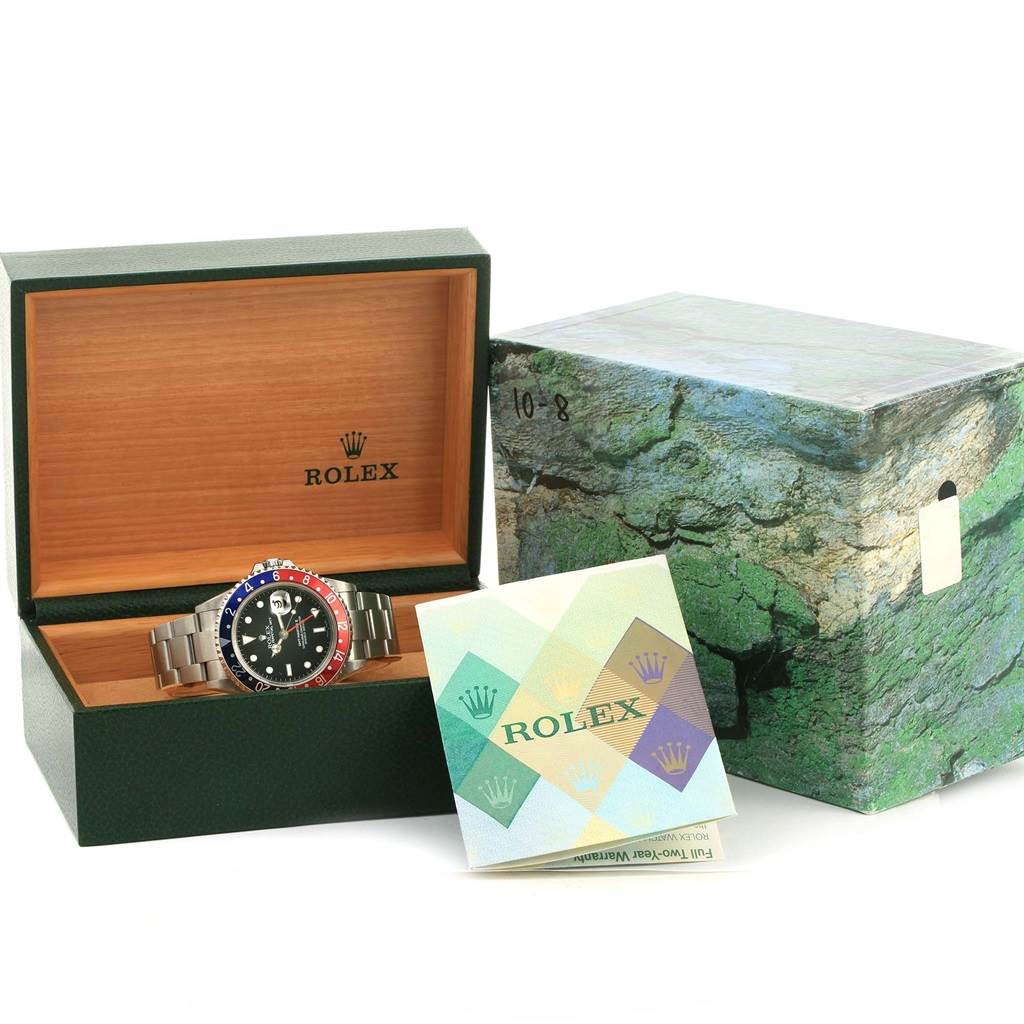 The image shows a Rolex GMT-Master 16710 Men's Stainless Steel Black Dial 16710 Men's Stainless Steel Black Dial watch inside its open green and wooden box, alongside its outer packaging and a Rolex manual.