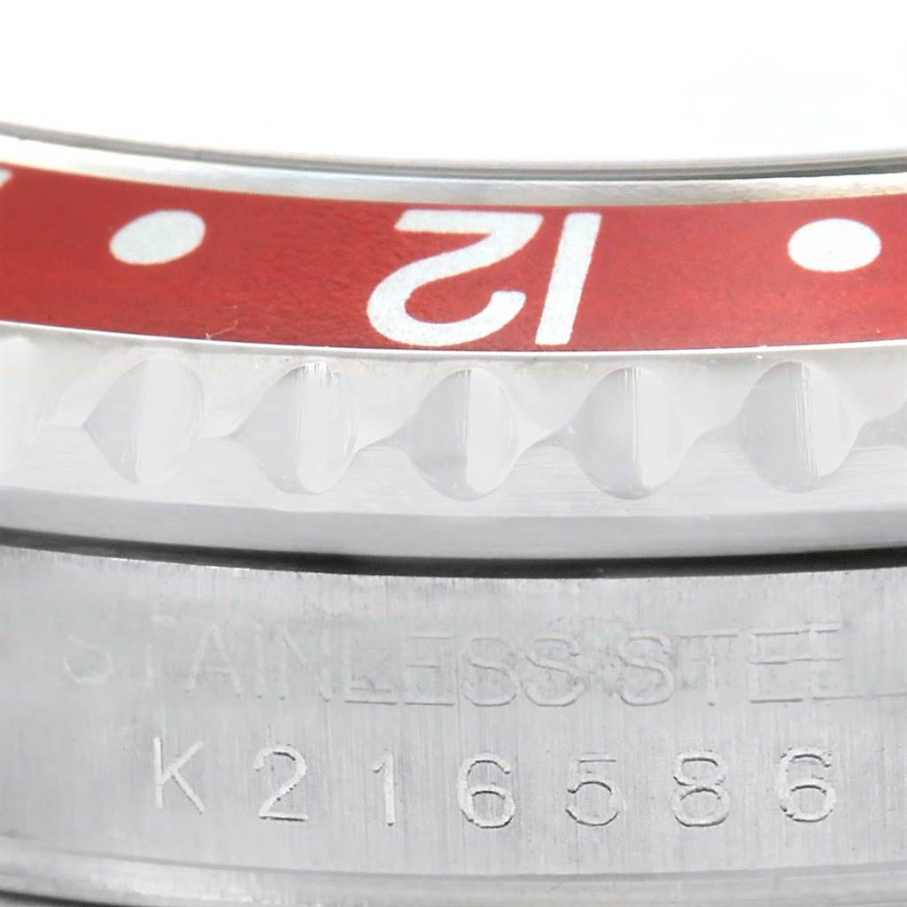 This close-up image of a Rolex GMT-Master 16710 Men's Stainless Steel Black Dial 16710 Men's Stainless Steel Black Dial shows the bezel's edge and part of the case with a serial number.