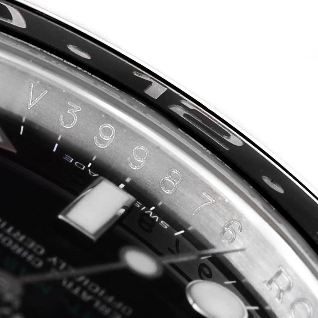 This close-up shows part of the bezel, the dial, and engraved serial numbers of the Rolex GMT-Master 116710 Men's Stainless Steel Black Dial 116710 Men's Stainless Steel Black Dial watch.