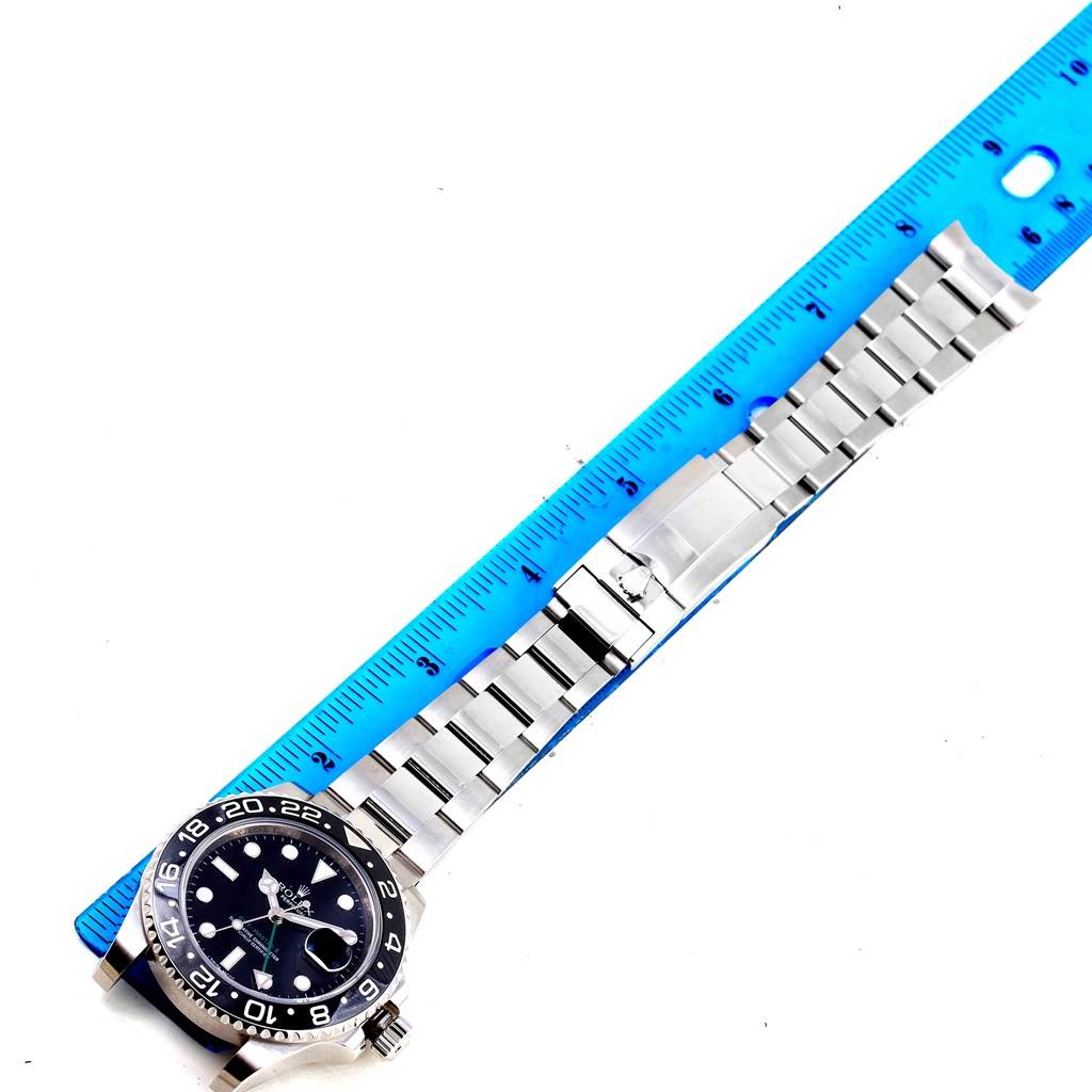 The image shows a Rolex GMT-Master 116710 Men's Stainless Steel Black Dial 116710 Men's Stainless Steel Black Dial watch laid flat with its stainless steel bracelet placed next to a blue ruler for scale.