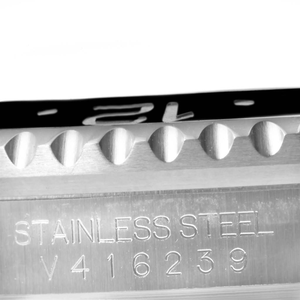 This close-up image shows the serrated bezel and part of the case with engravings of the Rolex GMT-Master 116710 Men's Stainless Steel Black Dial 116710 Men's Stainless Steel Black Dial model.