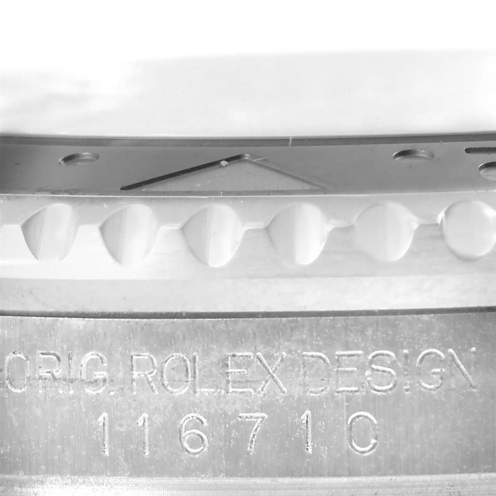 The image shows a close-up of the side view of a Rolex GMT-Master 116710 Men
s Stainless Steel Black Dial 116710 Men
s Stainless Steel Black Dial
s bezel and case with the model number 116710 engraved.