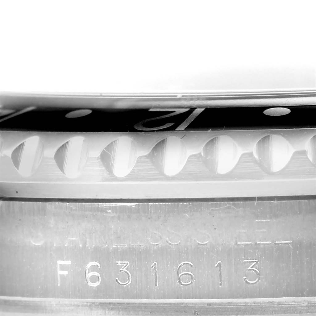 The photo shows a close-up side angle of a Rolex GMT-Master 16710 Men's Stainless Steel Black Dial 16710 Men's Stainless Steel Black Dial, focusing on its bezel, crystal, and part of the casing with engravings.