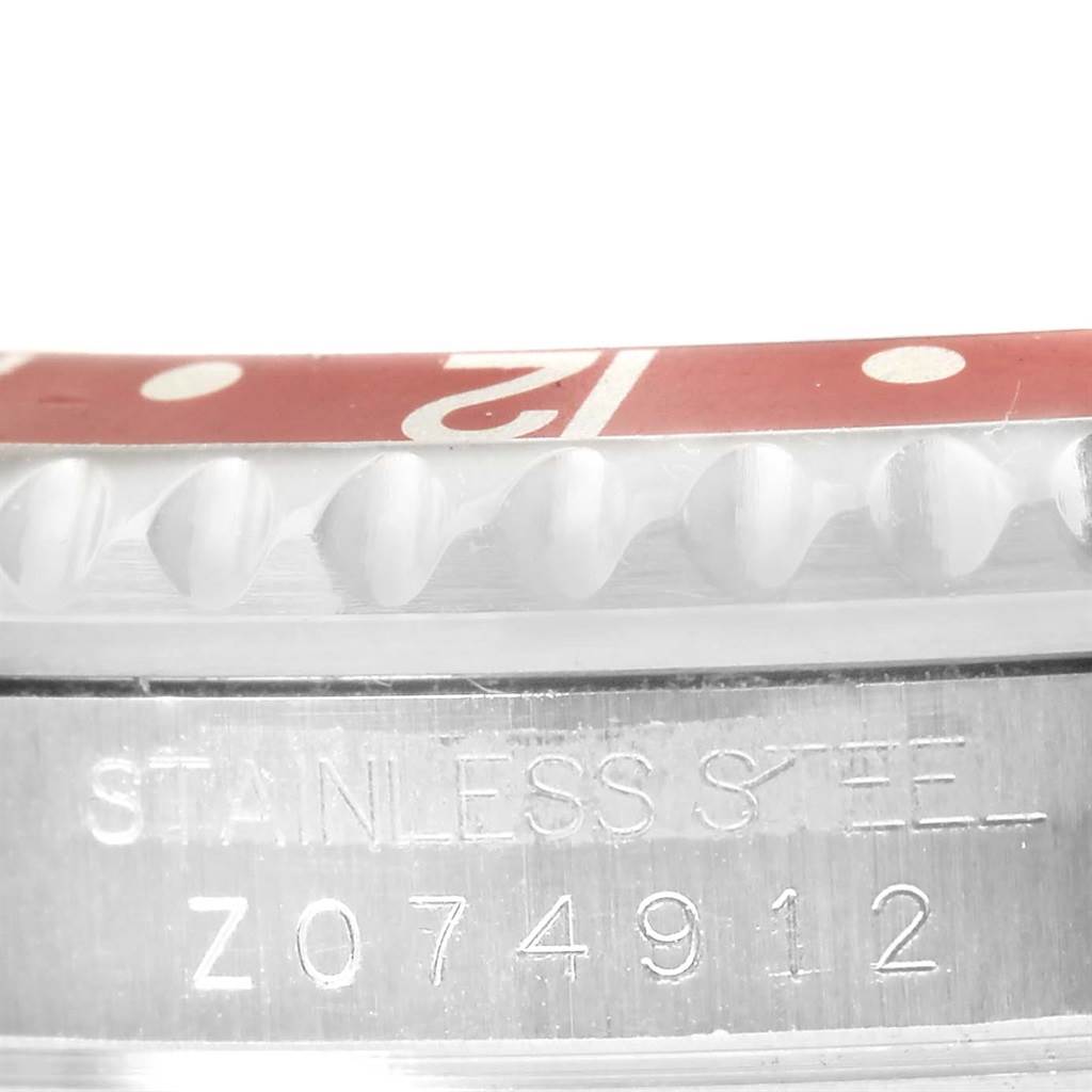 This close-up image shows the stainless steel case and bezel of a Rolex GMT-Master 16710 Men's Stainless Steel Black Dial 16710 Men's Stainless Steel Black Dial watch, including part of its serial number.