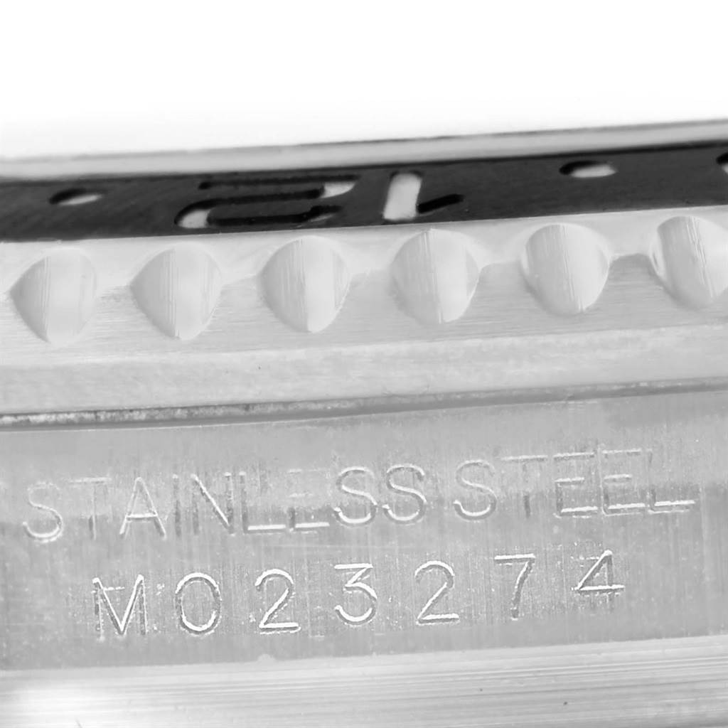 This close-up image shows the serial number engraving on the stainless steel rim of a Rolex GMT-Master 116710 Men's Stainless Steel Black Dial 116710 Men's Stainless Steel Black Dial watch bezel.