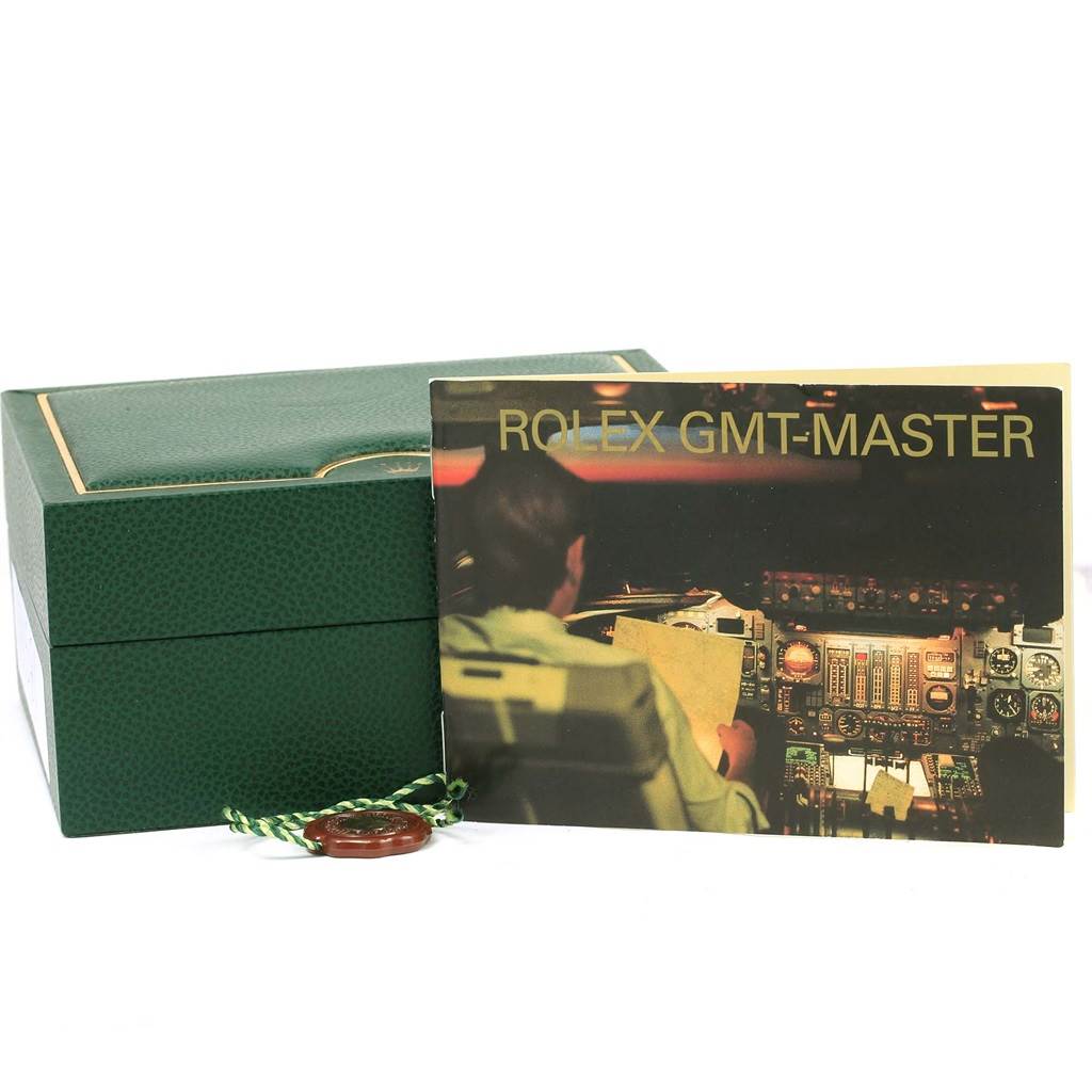 The image shows a green Rolex GMT-Master 16710 Men
s Stainless Steel Black Dial 16710 Men
s Stainless Steel Black Dial watch box and the associated manual positioned next to it.