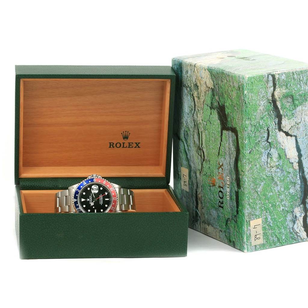 The Rolex GMT-Master 16700 Men's Stainless Steel Black Dial 16700 Men's Stainless Steel Black Dial watch is shown in an open green box, with the outer box placed beside it.