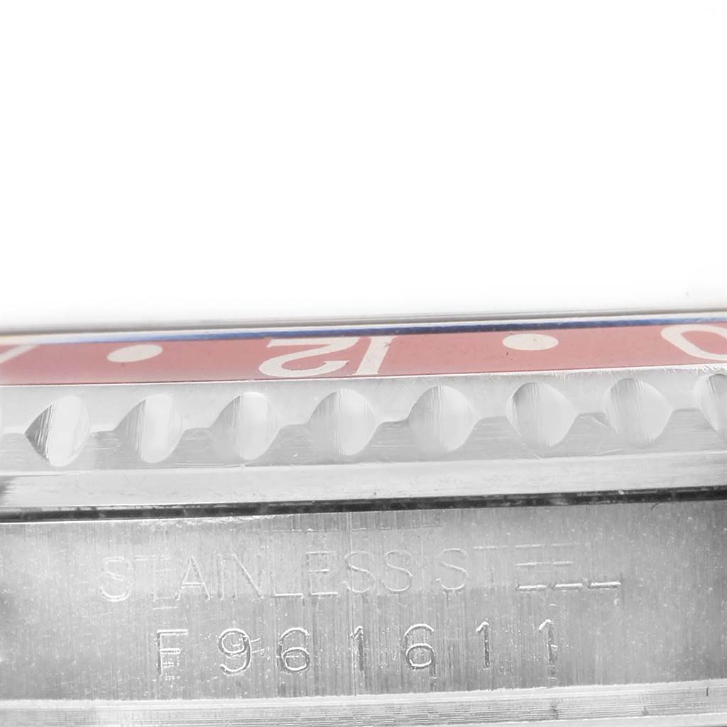 The image shows a close-up of the bezel and the serial number engraved on the case side of the Rolex GMT-Master 16710 Men's Stainless Steel Black Dial 16710 Men's Stainless Steel Black Dial watch.