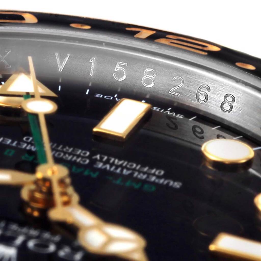 This close-up angle of the Rolex GMT-Master 116713 Men's Stainless Steel Black Dial 116713 Men's Stainless Steel Black Dial shows part of the bezel, serial number, and dial with gold hour markers and hands.