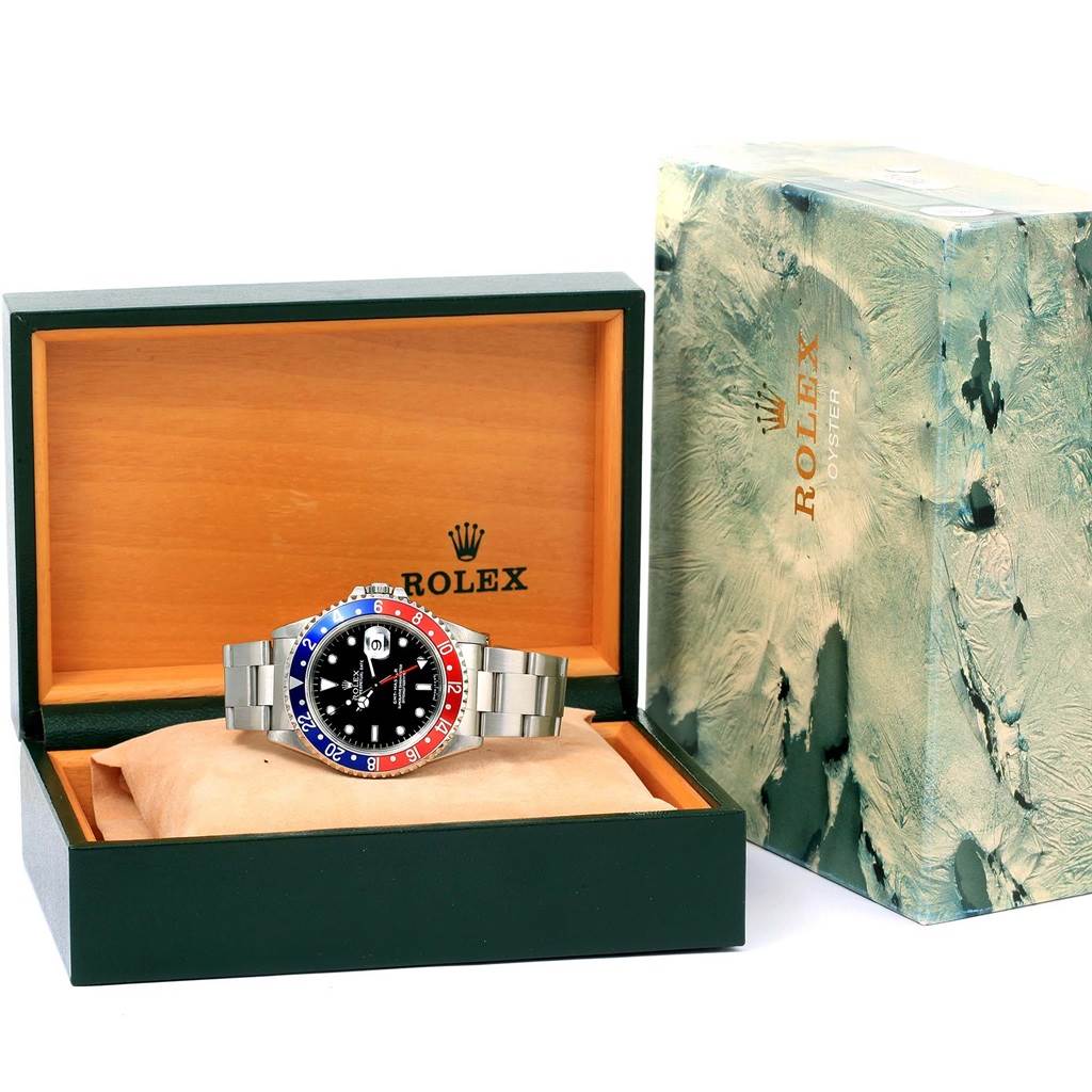 The Rolex GMT-Master 16700 Men's Stainless Steel Black Dial 16700 Men's Stainless Steel Black Dial watch is displayed in an open box, showing the face, bezel, and stainless steel bracelet.