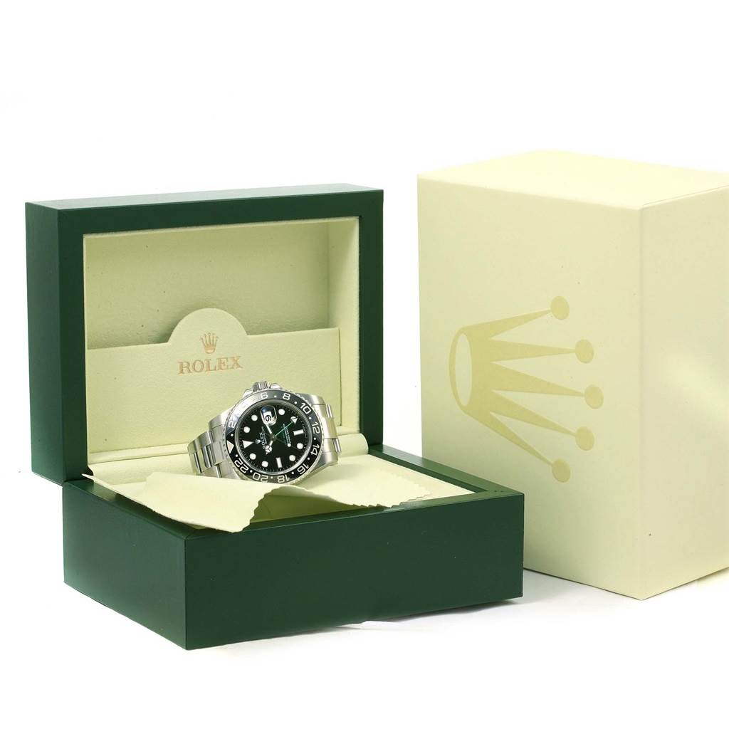 The Rolex GMT-Master 116710 Men's Stainless Steel Black Dial 116710 Men's Stainless Steel Black Dial watch is shown at a slight angle in an open green and beige Rolex box, accompanied by the outer packaging.