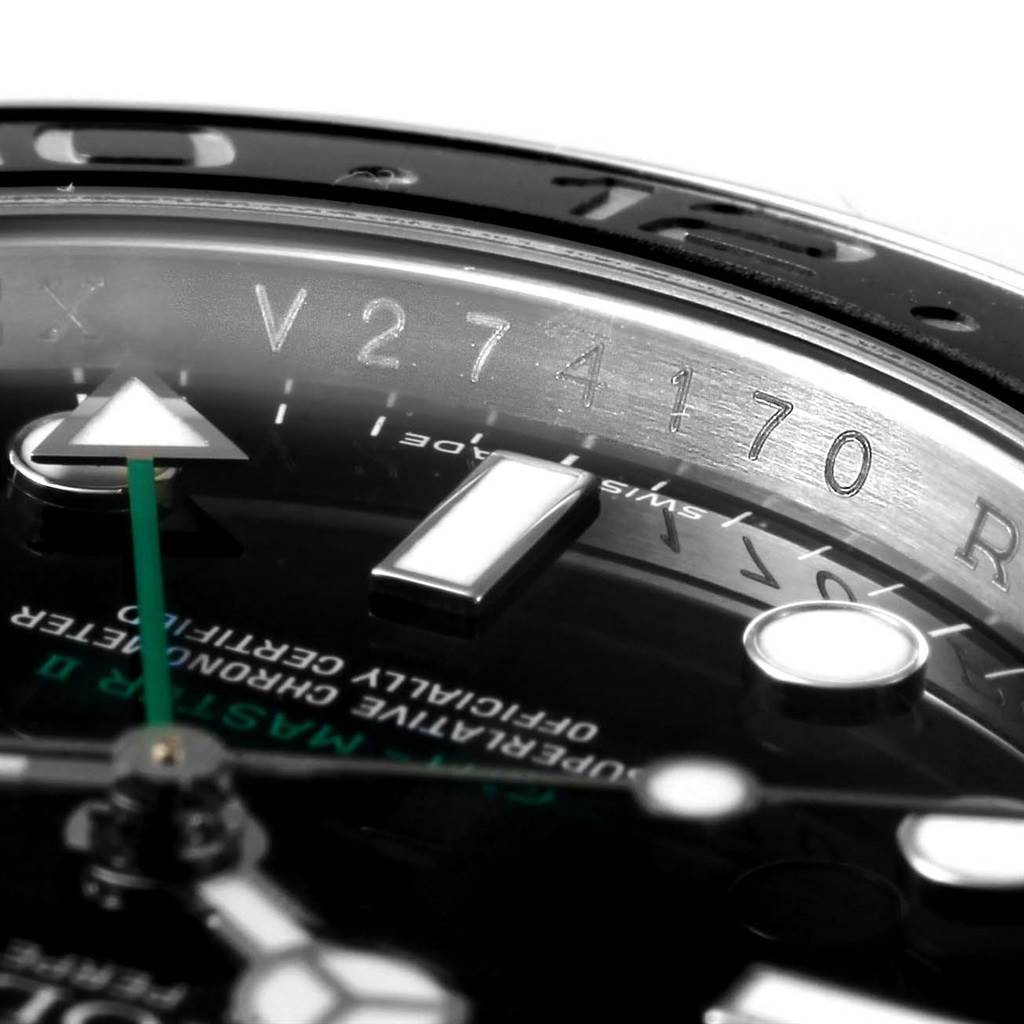This close-up image of the Rolex GMT-Master 116710 Men's Stainless Steel Black Dial 116710 Men's Stainless Steel Black Dial watch shows the serial number, part of the bezel, dial, and hands.