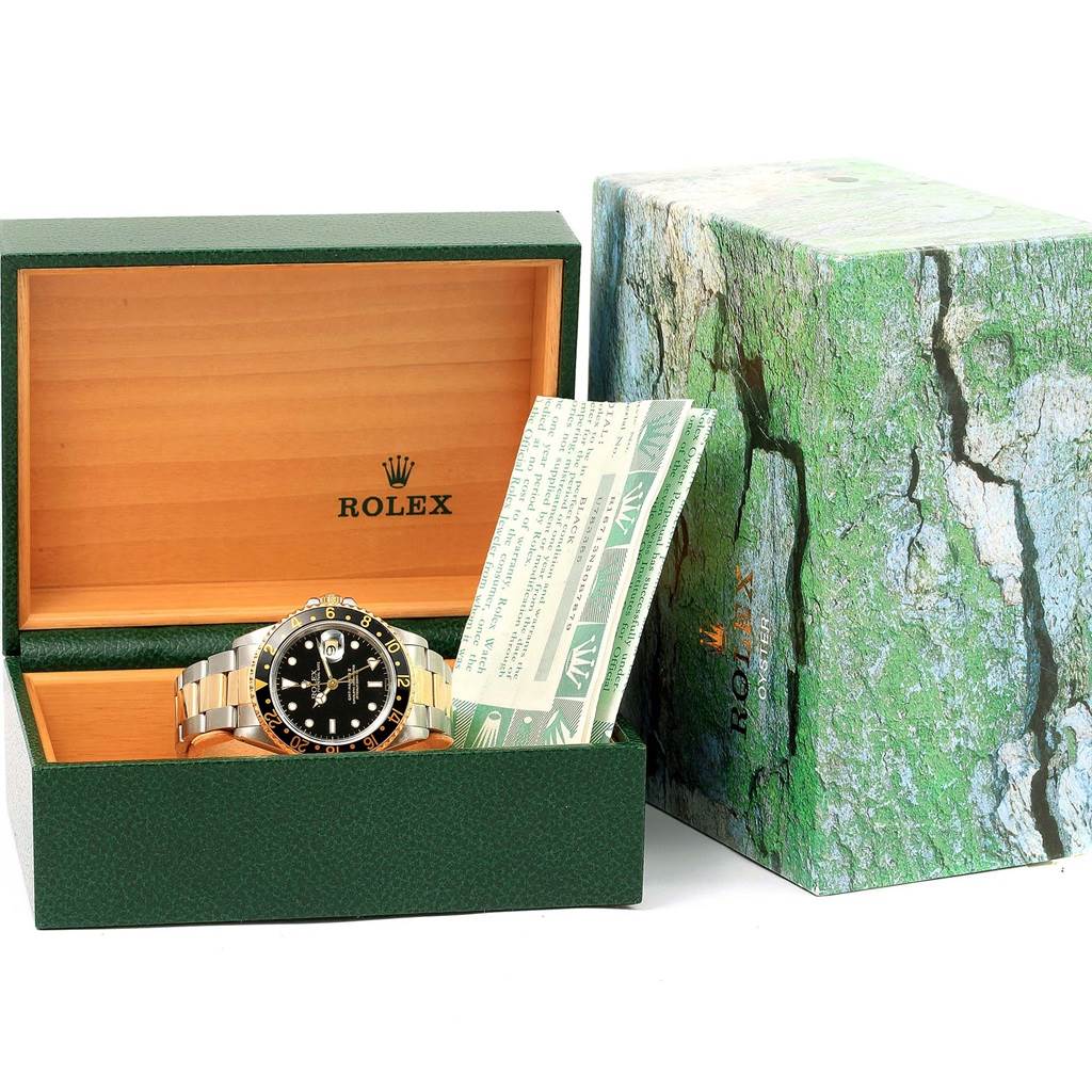 The Rolex GMT-Master 16713 Men's Stainless Steel Black Dial 16713 Men's Stainless Steel Black Dial watch is shown inside its open green and wood box, along with its official documentation.