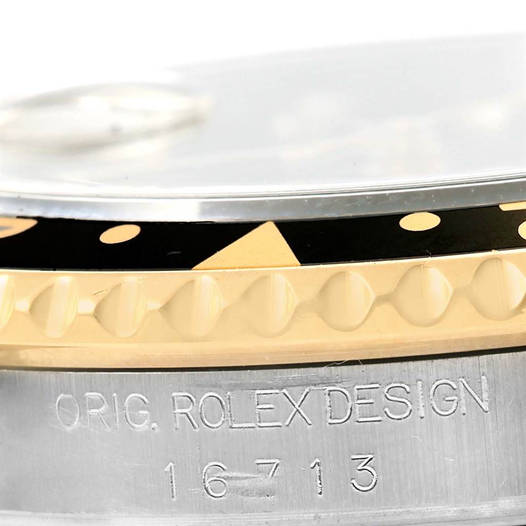 Close-up of the Rolex GMT-Master 16713 Men's Stainless Steel Black Dial 16713 Men's Stainless Steel Black Dial's bezel and casing, showcasing the serial number and design engraving.