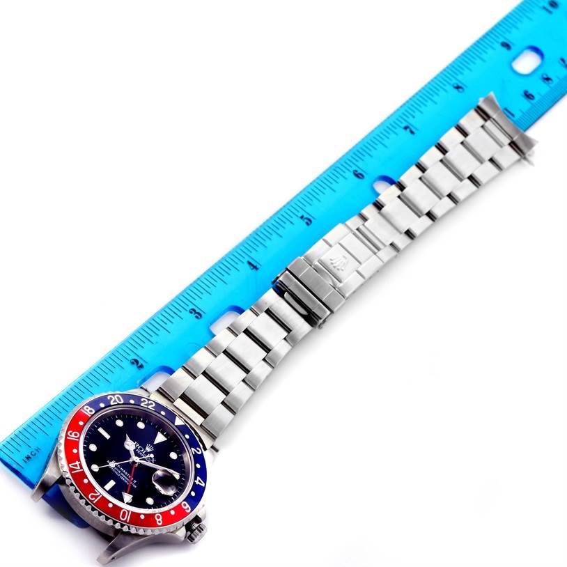 The image shows a Rolex GMT-Master 16710 Men's Stainless Steel Black Dial 16710 Men's Stainless Steel Black Dial watch laid flat, with its bezel, dial, and bracelet fully extended next to a ruler.