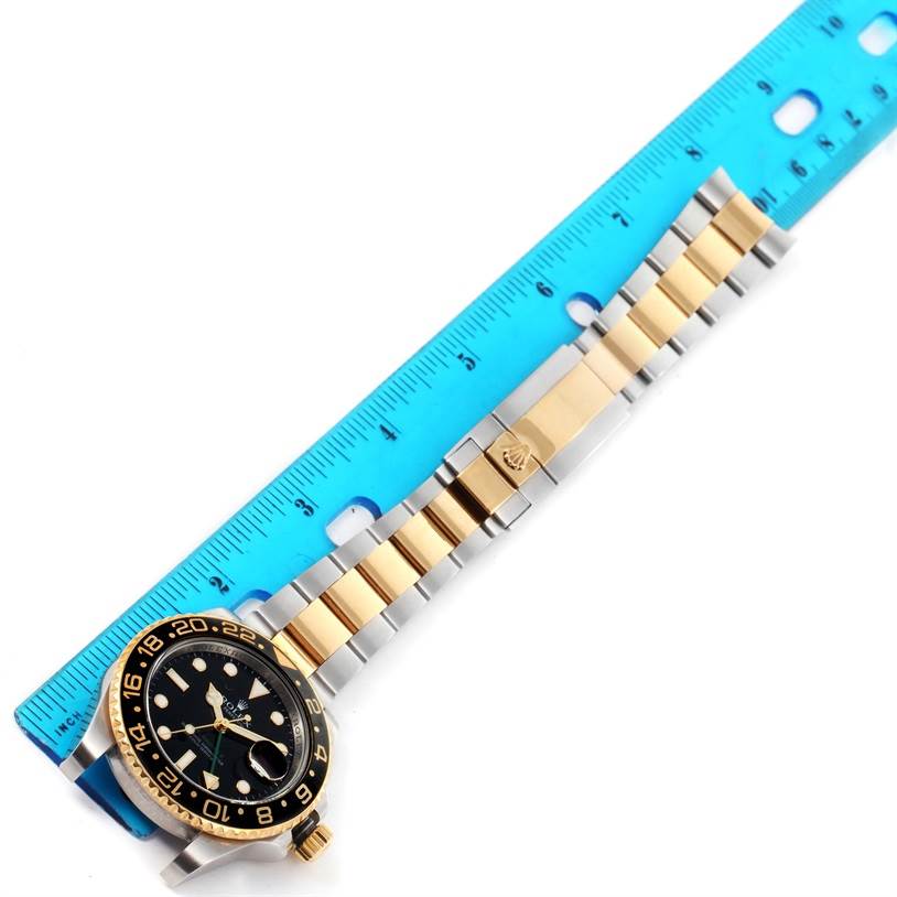 The image shows a Rolex GMT-Master 116713 Men's Stainless Steel Black Dial 116713 Men's Stainless Steel Black Dial watch laid flat with a two-tone bracelet next to a blue ruler for measurement.