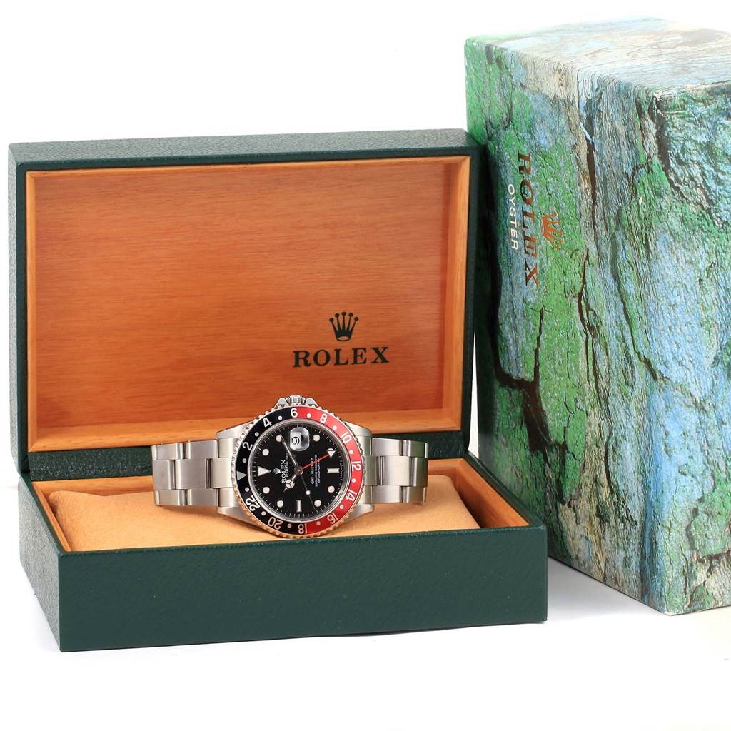 The image shows a Rolex GMT-Master 16710 Men's Stainless Steel Black Dial 16710 Men's Stainless Steel Black Dial watch placed inside an open green and wooden Rolex box with its detailed head and bracelet visible.