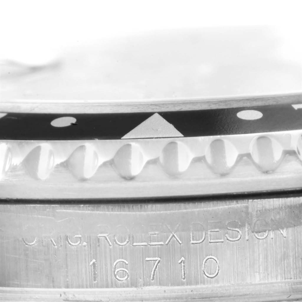 The image shows a close-up of the Rolex GMT-Master 16710 Men's Stainless Steel Black Dial 16710 Men's Stainless Steel Black Dial bezel and part of the case with the model number 16710 engraved.