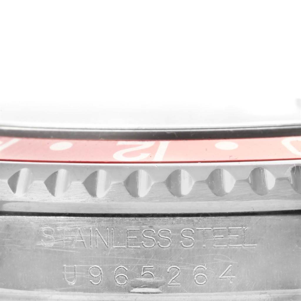 This close-up image of a Rolex GMT-Master 16710 Men's Stainless Steel Black Dial 16710 Men's Stainless Steel Black Dial watch highlights the stainless steel case and part of the red bezel.