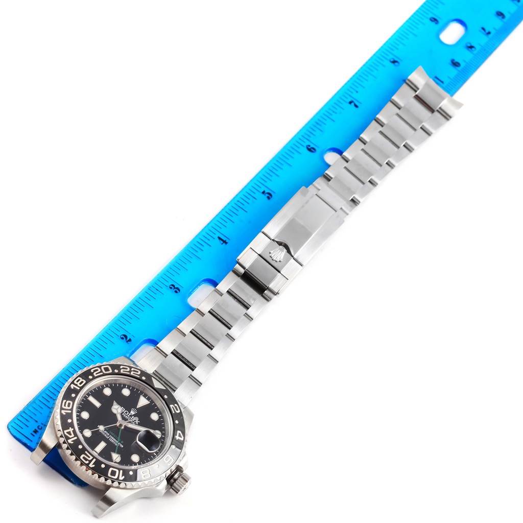 The image shows a Rolex GMT-Master 116710 Men's Stainless Steel Black Dial 116710 Men's Stainless Steel Black Dial watch laid flat next to a blue ruler, showcasing its bracelet and clasp.