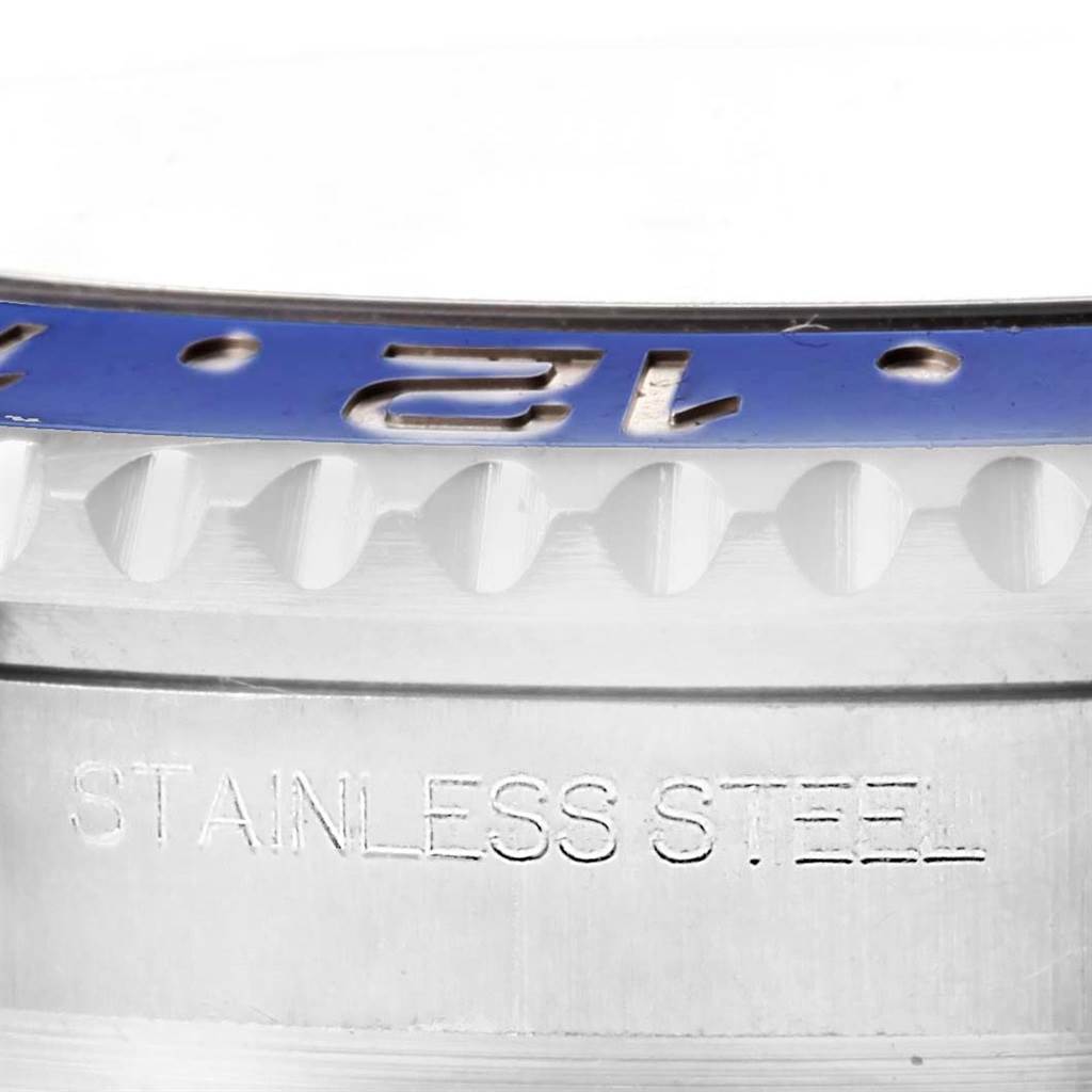 This close-up image of a Rolex GMT-Master 116710 Men
s Stainless Steel Black Dial 116710 Men
s Stainless Steel Black Dial watch shows part of the bezel and case, highlighting the "STAINLESS STEEL" engraving.