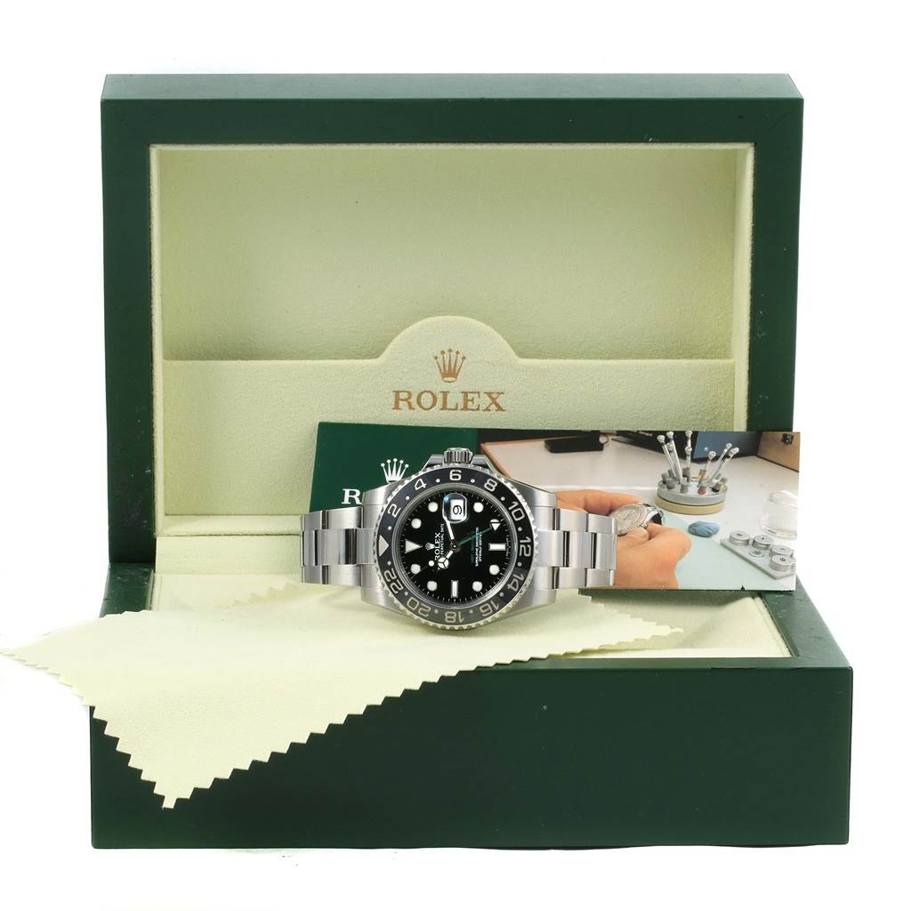 This Rolex GMT-Master 116710 Men's Stainless Steel Black Dial 116710 Men's Stainless Steel Black Dial watch is displayed in an open green box with a card and cleaning cloth.